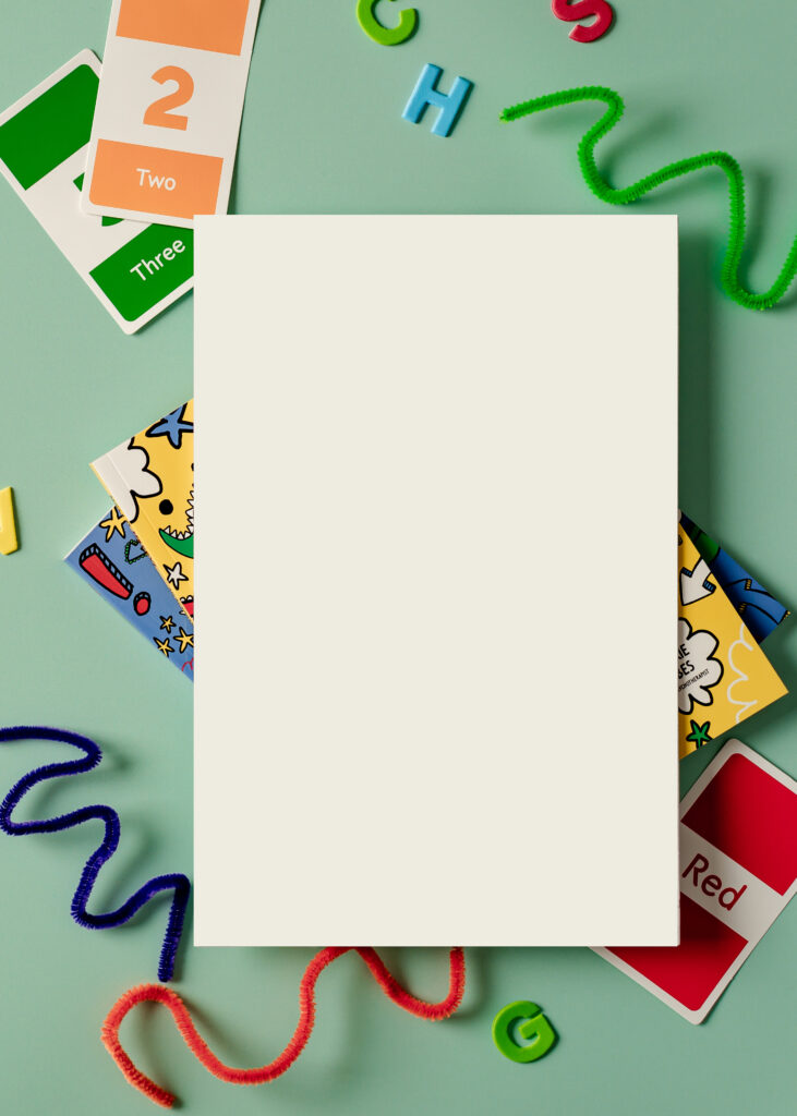 a blank white piece of paper on top of colorful cards all on top of a light green table